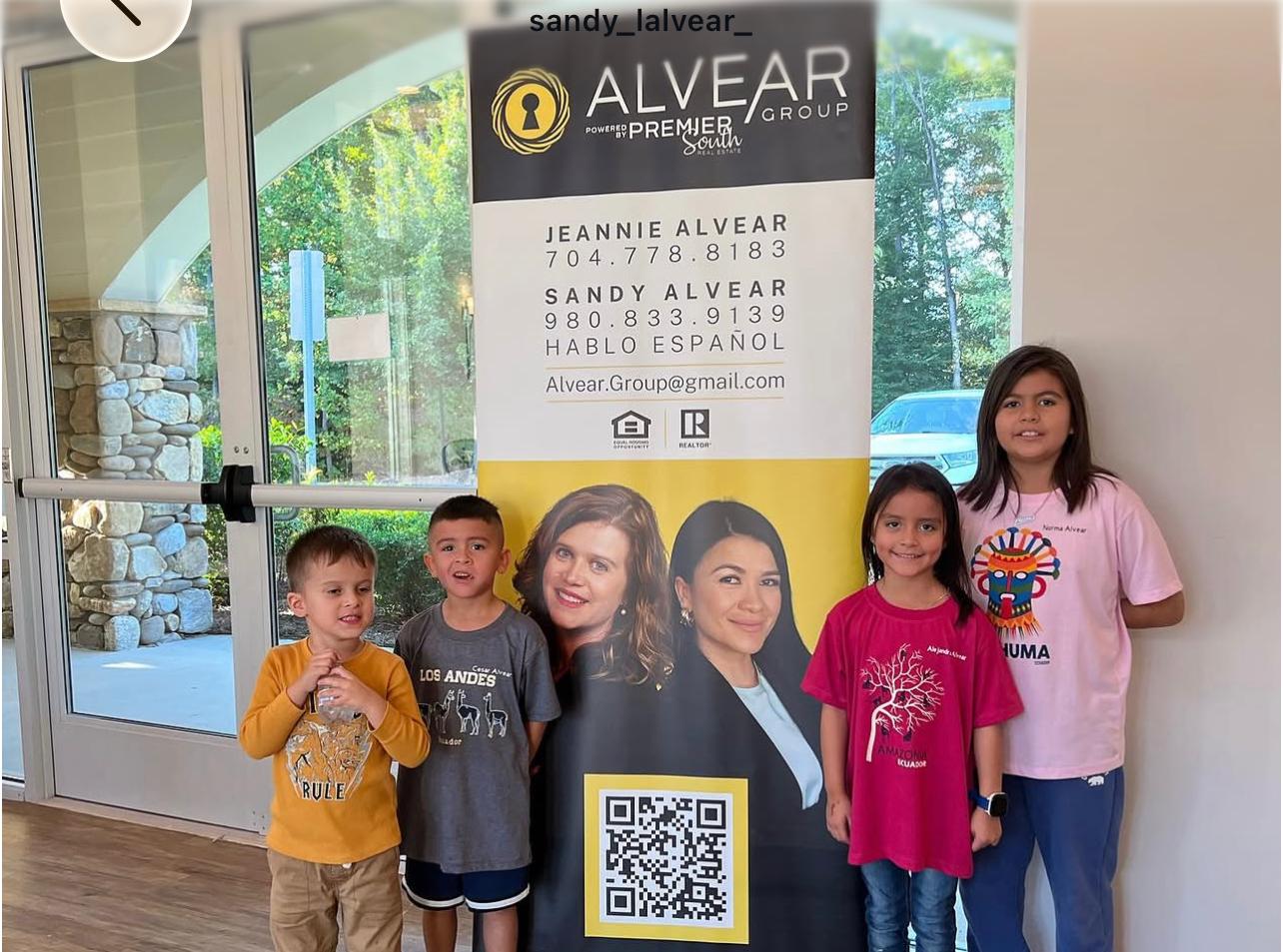 Kids with Alvear Group banner at community event
